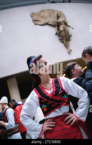 Tirana, Albania - novembre 28: Una studentessa in tradizionale abbigliamento albanese posa di fronte alla statua di madre Teresa al Palazzo Foto Stock