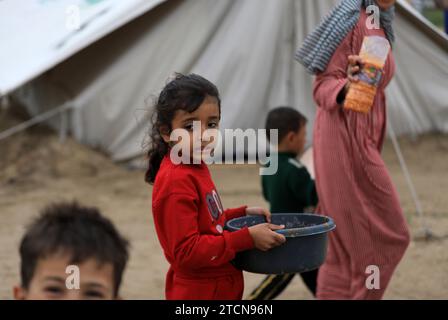 Gaza. 13 dicembre 2023. I bambini palestinesi sono visti in un rifugio temporaneo nella città meridionale di Rafah, nella Striscia di Gaza, il 13 dicembre 2023. Il leader di Hamas Ismail Haniyeh ha affermato mercoledì che la fazione palestinese al governo di Gaza è pronta a discutere con Israele qualsiasi accordo o iniziativa che possa portare a un cessate il fuoco a Gaza. Crediti: Yasser Qudih/Xinhua/Alamy Live News Foto Stock