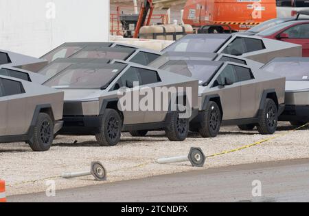 Austin, Texas, Stati Uniti. 13 dicembre 2023. I nuovi Tesla Cybertruck sono parcheggiati fuori dall'enorme fabbrica Tesla nel sud-est di Austin mentre i lavoratori effettuano controlli sulle attrezzature e li allontanano il 13 dicembre 2023, due settimane dopo aver consegnato i primi modelli agli acquirenti VIP in una cerimonia privata. È in corso una massiccia espansione presso lo stabilimento Tesla in Texas, con la costruzione di diversi nuovi edifici. (Immagine di credito: © Bob Daemmrich/ZUMA Press Wire) SOLO USO EDITORIALE! Non per USO commerciale! Foto Stock