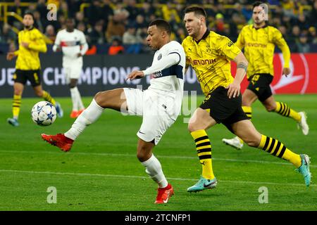 Dortmund, Germania. 13 dicembre 2023. Kylian Mbappe (L, davanti) del Paris Saint-Germain gareggia durante la partita del gruppo F di UEFA Champions League tra Borussia Dortmund e Paris Saint-Germain (PSG) a Dortmund, Germania, il 13 dicembre 2023. Crediti: Joachim Bywaletz/Xinhua/Alamy Live News Foto Stock