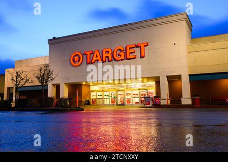 Issaquah, Washington, USA - 10 dicembre 2023; facciata del negozio Target con asfalto bagnato che riflette il segno rosso su un marciapiede umido Foto Stock