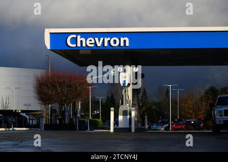 Bellevue, WA, USA - 10 dicembre 2023; cartello Chevron sulla tenda della stazione di servizio in blu e bianco con il tempo umido Foto Stock