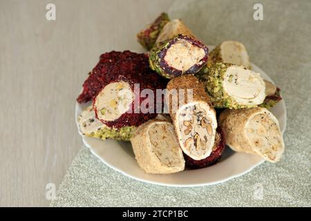 Molti panini di delizia turca con diversi sapori e ripieni in un piatto bianco sul tavolo. Tagli di dolci Turk Lokumu Foto Stock