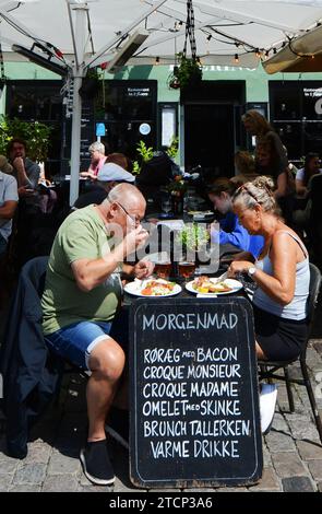 Turista che si gode il tradizionale Smørrebrød danese nei ristoranti di Nyhavn, Copenaghen, Danimarca. Foto Stock