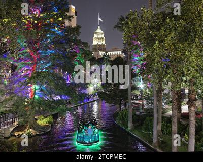 Battello fluviale sul fiume San Antonio con il Tower Life Building sullo sfondo di notte, Riverwalk , San Antonio, Texas Foto Stock
