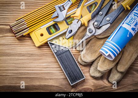 Composizione di utensili da costruzione su un vecchio pannello di legno Foto Stock