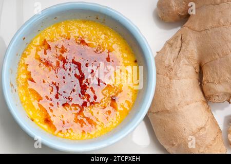 Dessert macro brulee con crema di zenzero fresco e radici di zenzero crude Foto Stock