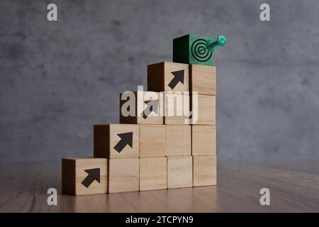 Blocchi di legno con freccia e tabellone di puntamento. Spazio di copia per il testo. Obiettivi aziendali, obiettivi e concetto di missione. Foto Stock