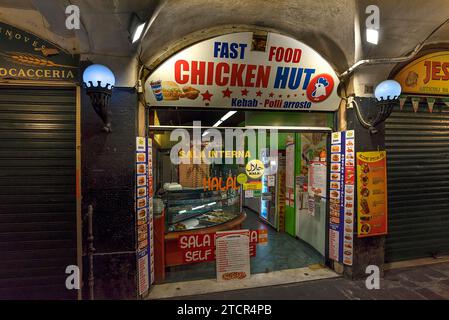 Snack bar fast food aperto la sera nei vecchi portici del porto di Genova Foto Stock