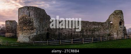 Vista panoramica a est del castello di Pevensey subito dopo l'alba di dicembre vicino alla costa orientale del Sussex, Inghilterra sud-orientale, Regno Unito Foto Stock