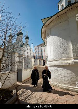 I sacerdoti ortodossi russi camminano nel cortile della Chiesa della decapitazione di Giovanni Battista del XVII secolo di Bohr. Mosca, Russia. Foto Stock