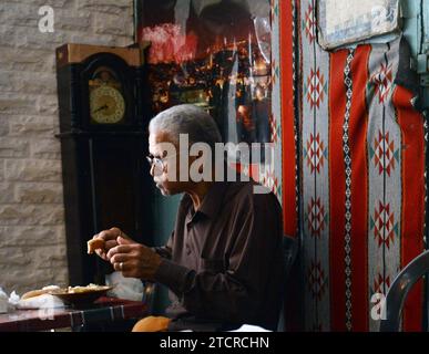 Un uomo palestinese che mangia hummus a Hummus Abu Kamel nel quartiere cristiano della città vecchia di Gerusalemme. Foto Stock