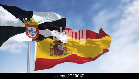 Ceuta e le bandiere nazionali spagnole sventolano in una giornata limpida. Città autonoma spagnola. Palestra bianca e nera con stemma municipale centrale. illus 3d. Foto Stock