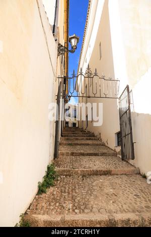 Stretta strada acciottolata e facciate della città di Ronda, Malaga, Spagna Foto Stock