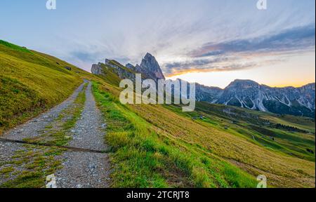 Alba dorata a Seceda, Dolomiti, Italia, che illumina l'aspro paesaggio, diffonde un caldo bagliore sulle vette iconiche e crea una tranquilla mattinata Foto Stock