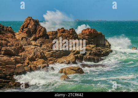 Onde contro le rocce granitiche erose di Ploumanaca'h sulla costa di granito rosa, Côtes-d'Armor, Bretagna, Bretagna, Bretagna, Francia Foto Stock