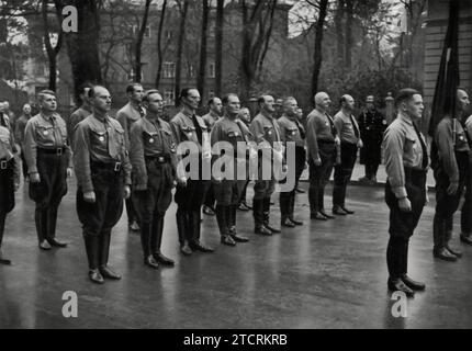 Il 9 novembre 1935, Adolf Hitler, accompagnato da alcuni dei più alti ufficiali del partito nazista, tra cui figure come Hermann Göring ed Erich Raeder, viene visto di fronte alla Casa Brown di Monaco con i "vecchi combattenti" del partito. Questo incontro presso la sede del partito nell'anniversario del Putsch di Beer Hall del 1923 sottolinea il significato della lealtà e il ricordo delle prime lotte del partito, evidenziando la presenza di leader chiave che hanno plasmato il regime nazista. Foto Stock