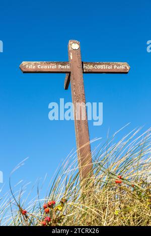 Un cartello in legno del sentiero costiero Fife contro un cielo blu Foto Stock