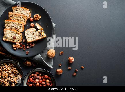 Gustosi biscotti tradizionali fatti in casa su sfondo nero da tavolo. Deliziosi biscotti cantucci con noci e uva passa. Foto Stock