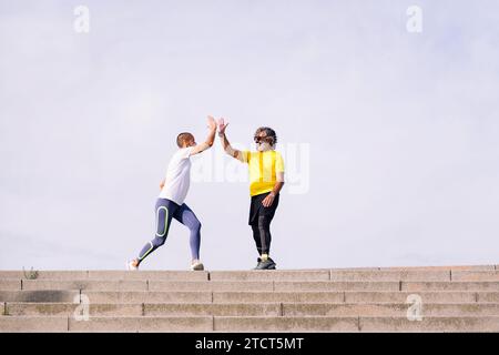 uomo che celebra il successo dell'impegno con l'istruttore Foto Stock