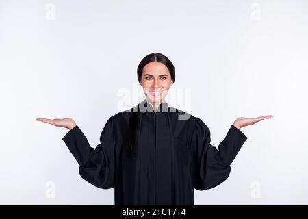 Foto di felice sorridente allegro adorabile avvocato donna tiene la mano in equilibrio pubblicizza isolato su sfondo di colore bianco Foto Stock