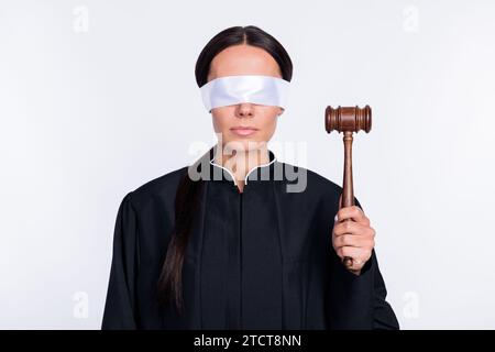Foto di una donna seria giudice con gli occhi chiusi che tiene in mano il martelletto indossa un verdetto di abito nero isolato su sfondo di colore bianco Foto Stock