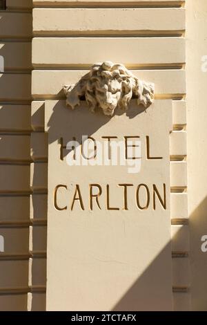 Il nome dell'Hotel Carlton / Carlton Cannes Hotel, Cannes, in stucco di cemento sul lato dell'edificio. Decorazione della testa di Leone sopra. (135) Foto Stock