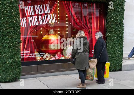 I turisti di Natale si divertono nei grandi magazzini di lusso Selfridges su Oxford Street, vetrina natalizia natalizia, nel centro di Londra, in Inghilterra, nel Regno Unito Foto Stock