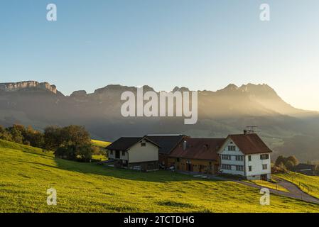 Fattoria solitaria sulle Alpi Appenzell di fronte alle montagne Alpstein con Saentis, Canton Appenzello Innerrhoden, Svizzera Foto Stock