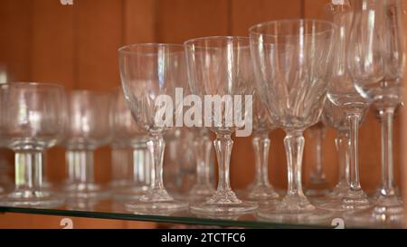 File di bicchieri da vino allineate sullo scaffale di un armadietto per porcellana. Foto Stock