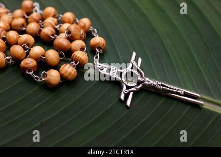 Rosario o perline di preghiera in permesso verde. Gesù sulla croce. Crucifix. Foto Stock