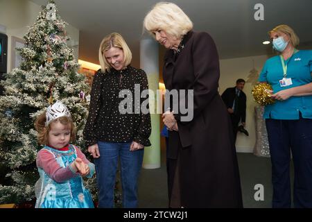 La regina Camilla parla con una giovane ragazza vestita da principessa mentre arriva per incontrare bambini, famiglie e personale al Childrens Hospice South West's (CHSW) Charlton Farm Children's hospice, a Bristol. Data immagine: Giovedì 14 dicembre 2023. Foto Stock