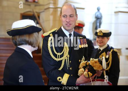 Il principe di Galles riceve un dono presso le divisioni Lord High Admiral presso il Britannia Royal Naval College di Dartmouth, dove assistette a una sfilata di 202 cadetti della Royal Navy che passavano con i cadetti degli ufficiali internazionali dell'Oman, del Kuwait, del Bangladesh e di Trinidad e Tobago. Data immagine: Giovedì 14 dicembre 2023. Foto Stock