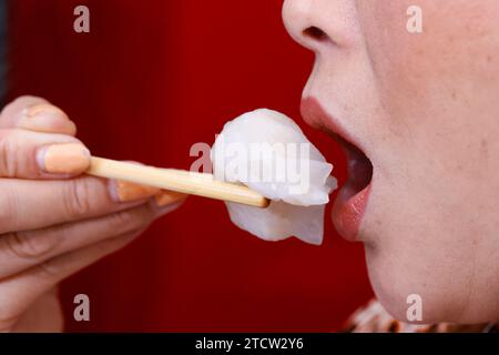 Donna che mangia Dim Sum. Primo piano sulle bacchette. Foto Stock