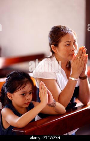 Dalat Cathedral. Madre e figlia che pregano insieme in chiesa. CAN Tho. Vietnam. Foto Stock