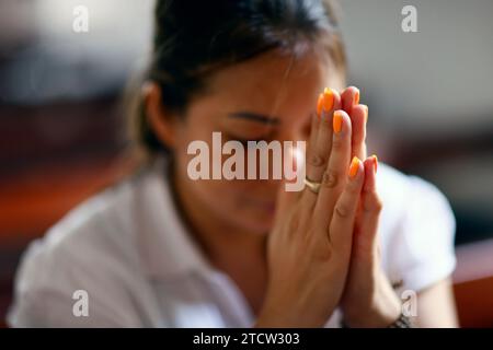 Donna cattolica che prega da sola in una chiesa. CAN Tho. Vietnam. Foto Stock