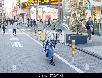 SAMURAI CHE RACCOLGONO RIFIUTI NELLE STRADE DI SHIBUYA A TOKYO Foto Stock