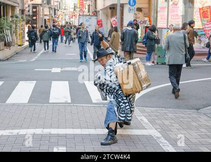 SAMURAI CHE RACCOLGONO RIFIUTI NELLE STRADE DI SHIBUYA A TOKYO Foto Stock