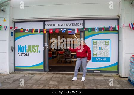 Slough, Regno Unito. 14 dicembre 2023. Orgogliosa Kate Borska, la Slough Store Manager. Un supermercato sociale chiamato notjust A Store ha aperto un nuovo grande negozio al Westgate Retail Park sulla A4 a Slough, Berkshire, accanto a Currys. L'enorme negozio vende cibo a prezzi scontati, dove i clienti possono riempire un cestino con articoli a £5 che costerebbero circa £15 altrove. Gran parte del cibo è passato il migliore prima della data o è in eccesso, ma è comunque perfettamente accettabile da consumare. È aperto a tutti coloro che odiano gli sprechi e amano fare affari. Gli acquirenti non devono essere membri per fare acquisti in negozio o avere entrate Foto Stock