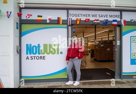 Slough, Regno Unito. 14 dicembre 2023. Orgogliosa Kate Borska, la Slough Store Manager. Un supermercato sociale chiamato notjust A Store ha aperto un nuovo grande negozio al Westgate Retail Park sulla A4 a Slough, Berkshire, accanto a Currys. L'enorme negozio vende cibo a prezzi scontati, dove i clienti possono riempire un cestino con articoli a £5 che costerebbero circa £15 altrove. Gran parte del cibo è passato il migliore prima della data o è in eccesso, ma è comunque perfettamente accettabile da consumare. È aperto a tutti coloro che odiano gli sprechi e amano fare affari. Gli acquirenti non devono essere membri per fare acquisti in negozio o avere entrate Foto Stock