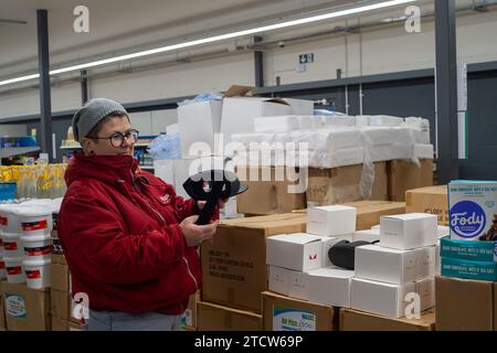 Slough, Regno Unito. 14 dicembre 2023. Kate Borska, Store Manager, con la vasta gamma di prodotti. Notjust A Store ha aperto un nuovo grande negozio al Westgate Retail Park sulla A4 a Slough, Berkshire, accanto a Currys. L'enorme negozio vende cibo a prezzi scontati, dove i clienti possono riempire un cestino con articoli a £5 che costerebbero circa £15 altrove. Gran parte del cibo è passato il migliore prima della data o è in eccesso, ma è comunque perfettamente accettabile da consumare. È aperto a tutti coloro che odiano gli sprechi e amano fare affari. Gli acquirenti non devono essere membri per fare acquisti in negozio o avere una soglia di reddito Foto Stock