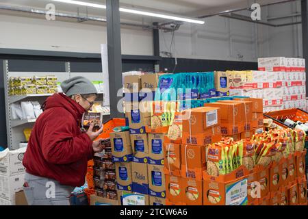 Slough, Regno Unito. 14 dicembre 2023. Kate Borska, Store Manager, con la vasta gamma di prodotti. Notjust A Store ha aperto un nuovo grande negozio al Westgate Retail Park sulla A4 a Slough, Berkshire, accanto a Currys. L'enorme negozio vende cibo a prezzi scontati, dove i clienti possono riempire un cestino con articoli a £5 che costerebbero circa £15 altrove. Gran parte del cibo è passato il migliore prima della data o è in eccesso, ma è comunque perfettamente accettabile da consumare. È aperto a tutti coloro che odiano gli sprechi e amano fare affari. Gli acquirenti non devono essere membri per fare acquisti in negozio o avere una soglia di reddito Foto Stock