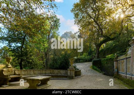 La luce del sole mette in evidenza il castello moresco in cima alla montagna Castelo dos Mouros, visto dai giardini del castello di Quinta de Regaleira a Sintra in Portogallo Foto Stock