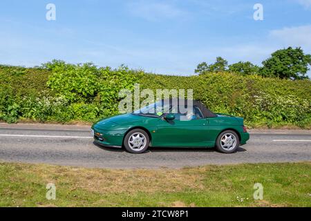 Anni '1990 90. Anni '90, cabriolet Mazda Miata verde; traffico veicolare, veicoli in movimento, cabriolet, veicoli che circolano su strade del Regno Unito, motori, motori sull'autostrada M6, rete stradale del Regno Unito. Foto Stock