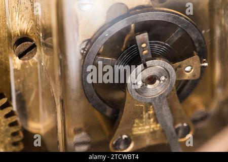 Dettagli orologio mantel vintage, foto ravvicinata con messa a fuoco selettiva di una ruota di bilanciamento Foto Stock