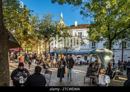 Gente che cammina per Place du Tertre guardando gli artisti e il loro lavoro in un pomeriggio d'inverno a Montmartre, Parigi, Francia Foto Stock