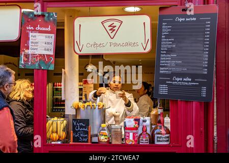 Una donna che compra VIN brulé o Vin Chaud al tutti sensi, un piccolo caffè in Rue Norvins, Montmartre, nel 18° arrondissement di Parigi, Francia Foto Stock