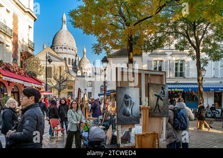 Gente che cammina per Place du Tertre guardando gli artisti e il loro lavoro in un pomeriggio d'inverno a Montmartre, Parigi, Francia Foto Stock