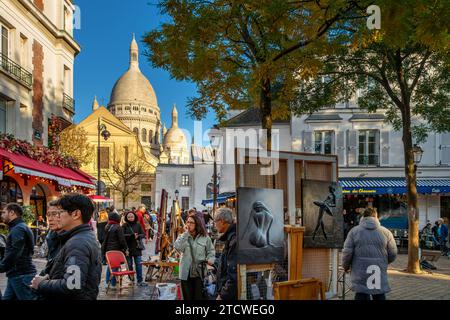 Gente che cammina per Place du Tertre guardando gli artisti e il loro lavoro in un pomeriggio d'inverno a Montmartre, Parigi, Francia Foto Stock