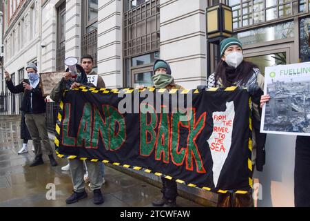 Londra, Regno Unito. 14 dicembre 2023. Gli attivisti pro-Palestina e per il clima del gruppo Fossil Free London bloccano gli ingressi al quartier generale del gigante di combustibili fossili BP nel centro di Londont. Israele ha recentemente concesso licenze alla BP per esplorare la costa di Gaza alla ricerca di gas mentre la guerra continua tra Israele e Hamas. Credito: Vuk Valcic/Alamy Live News Foto Stock